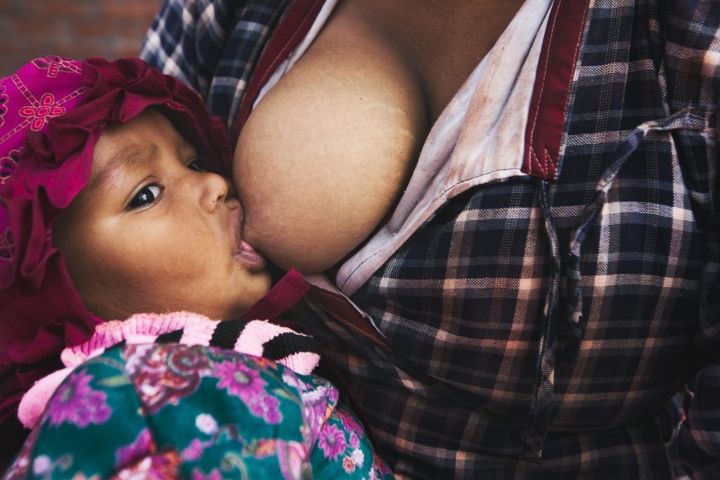 Flexibility while breastfeeding allows your baby to stay fed while on the go. Picture shows a mother feeding her baby,

